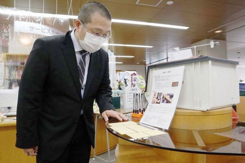 実証実験を進めている就実大の図書館で、抗菌シートを確認する山田講師