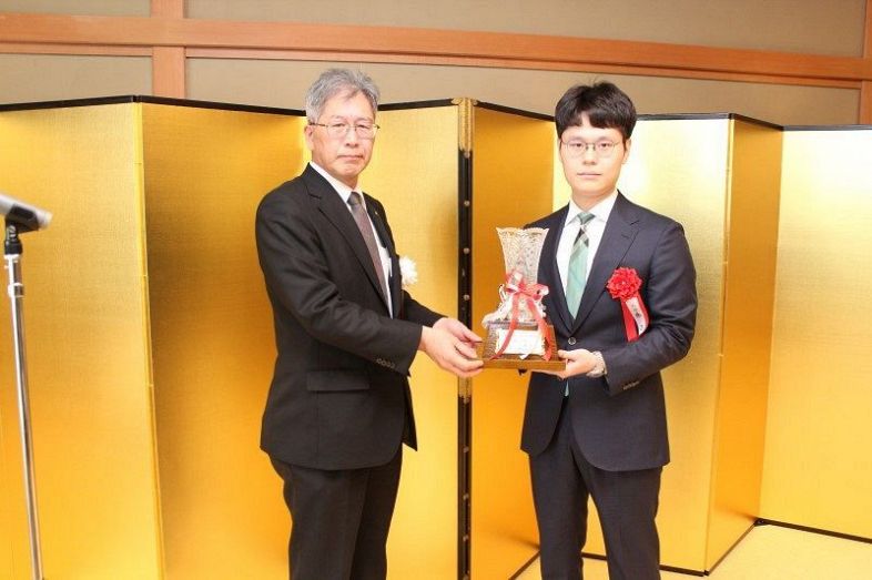 山陽新聞社の板谷編集局長から優勝カップを贈られた余第一位（右）