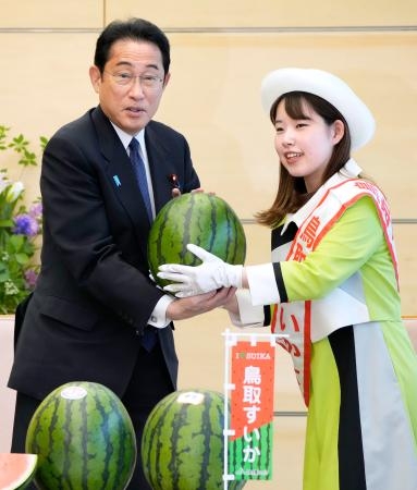 　鳥取のスイカを贈呈される岸田首相（左）＝３０日午前、首相官邸