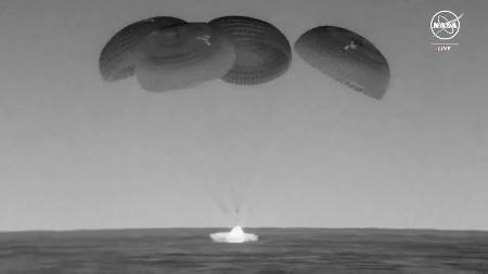 　パラシュートを開き、メキシコ湾に着水する古川聡飛行士らの乗った宇宙船クルードラゴン＝１２日（ＮＡＳＡの中継から・共同）