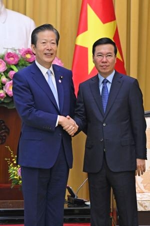 　ベトナム・ハノイでボー・バン・トゥオン国家主席（右）と握手する公明党の山口代表＝２３日（共同）