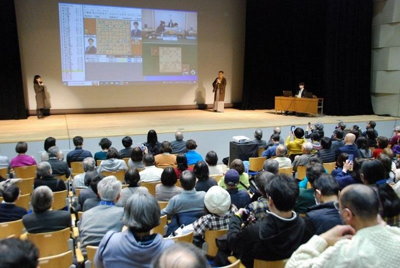 会場近くの立川市市民会館では、立会人・中村修九段らによる大盤解説会があり、首都圏を中心に全国から集まった将棋ファンが、勝負の行方を見守った