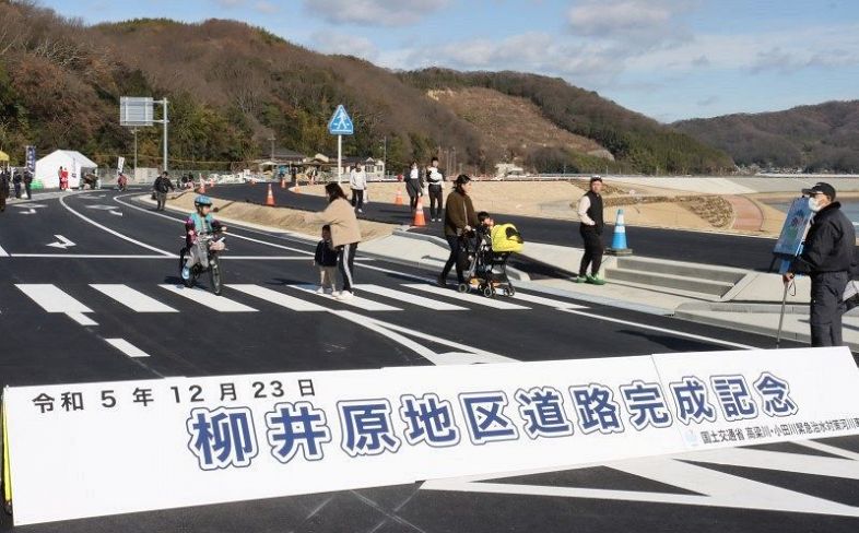 開通前の岡山県道バイパス（手前）と自転車・歩行者専用道を歩く地元住民ら