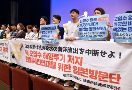 　原水爆禁止世界大会で処理水放出に反対する横断幕を掲げる韓国の市民団体メンバーら＝３０日午後、福島市