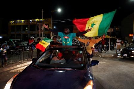 　ファイ氏優勢の知らせにセネガルの国旗を振って喜ぶ支持者たち＝２４日、ダカール（ロイター＝共同）