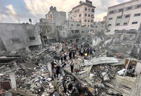 　イスラエル軍の攻撃により崩壊した建物跡で救助活動をする民間防衛チームのメンバーら＝６日、パレスチナ自治区ガザ北部ジャバリヤ（ゲッティ＝共同）