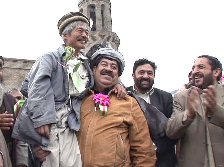 　映画「荒野に希望の灯をともす」の一場面。アフガン人と笑顔の中村哲さん（左端）（日本電波ニュース社提供）
