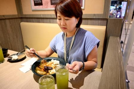 　１６日、シンガポールで展開中の福島県産食材のキャンペーンでカツカレーを食べる女性会社員（共同）
