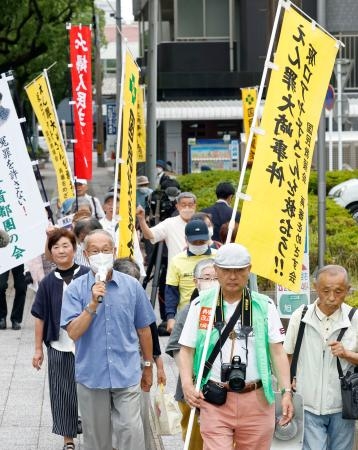 　福岡高裁宮崎支部が「大崎事件」の再審開始を認めない決定をしたことを受け、抗議の声を上げながら裁判所前を歩く支援者ら＝５日午前