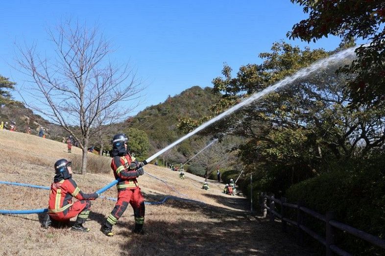林野火災を想定した訓練で放水する消防署員