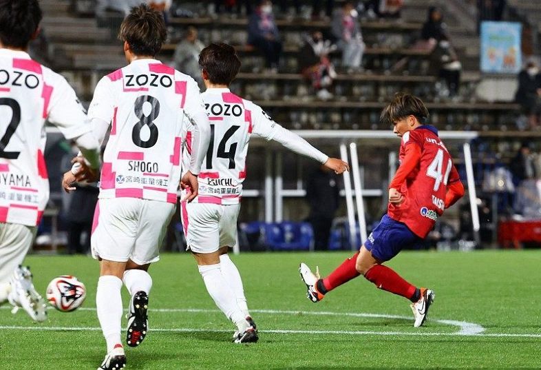 後半２１分、ファジアーノ岡山の仙波大志（右）がゴールを決め、２―１とする＝いちご宮崎新富サッカー場