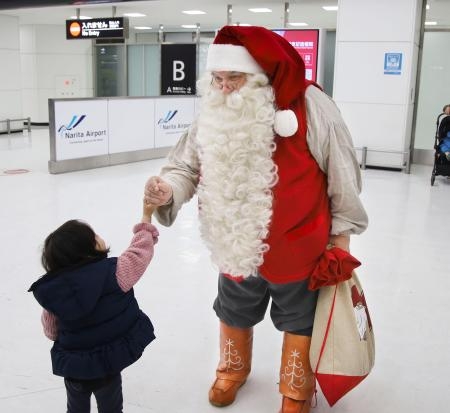 　フィンランドから成田空港に到着し、子どもと握手するサンタクロース＝１日午後