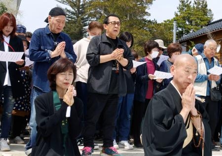 　石川県珠洲市の須須神社で、能登半島地震の犠牲者に手を合わせるさだまさしさん（中央）、泉谷しげるさん（その左）ら＝１５日午後