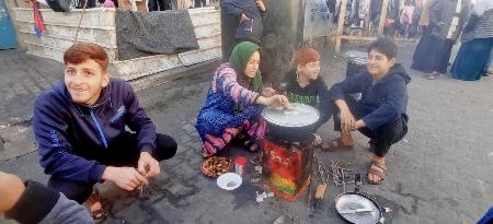 　屋外で料理する人々＝１２月３０日、パレスチナ自治区ガザ南部ラファ（ナビル・アブデヤさん提供・共同）
