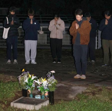 　東海大の学生が亡くなったアパート跡地で手を合わせる卒業生の橋村さくらさん（手前）ら＝１６日未明、熊本県南阿蘇村