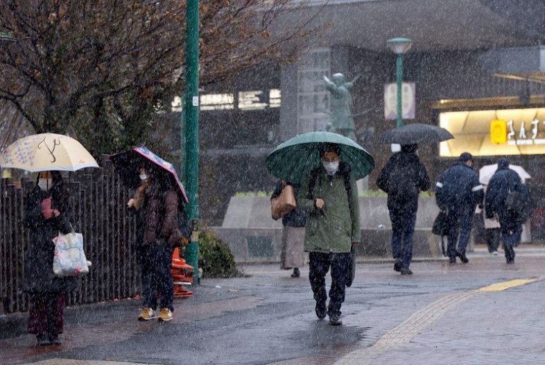 雪が降る中、通勤する会社員ら＝２７日午前８時２５分、ＪＲ岡山駅東口
