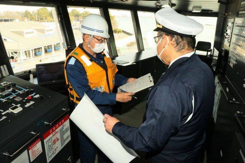 中村船長（右）に安全運航を呼びかける玉野海上保安部の職員