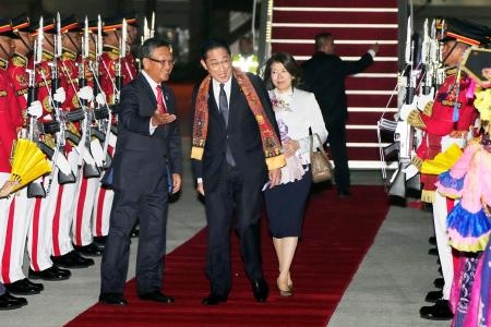 　ＡＳＥＡＮ関連首脳会議に出席するため、インドネシアの国際空港に到着した岸田首相（中央）。右は裕子夫人＝５日（共同）