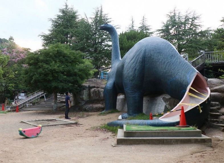 恐竜の形をした滑り台などが使用禁止となっている「太陽の丘公園」。奥は大型ローラー滑り台