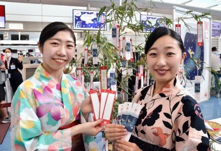　羽田空港で開かれた日本航空の七夕イベントで、短冊を手にする浴衣姿のスタッフ＝７日午前