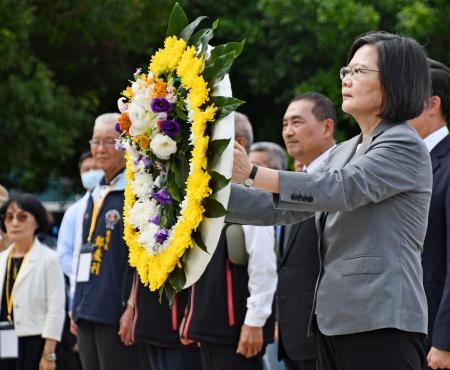 　２３日、台湾・金門島で行われた金門砲戦６５年の式典で、花輪を手にする蔡英文総統。その左は侯友宜・新北市長（共同）