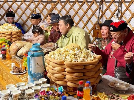 　故郷モンゴルのドルノド県の移動式住居ゲルで、地元の人らに大関昇進を祝われる霧島（右から３人目）＝９日（共同）