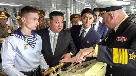 　フリゲート艦「マルシャル・シャポシニコフ」の艦上で説明を受ける北朝鮮の金正恩朝鮮労働党総書記（左から２人目）＝１６日、ロシア極東ウラジオストク（タス＝共同）