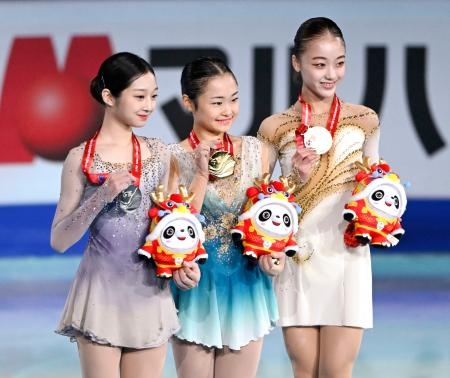 　ジュニア女子で２連覇を果たし、表彰式でメダルを手に笑顔を見せる島田麻央（中央）。右は３位の上薗恋奈＝北京（共同）