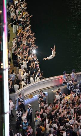 　阪神がセ・リーグ優勝を決めた夜に、大阪・ミナミの道頓堀川の遊歩道から飛び込む人＝１４日