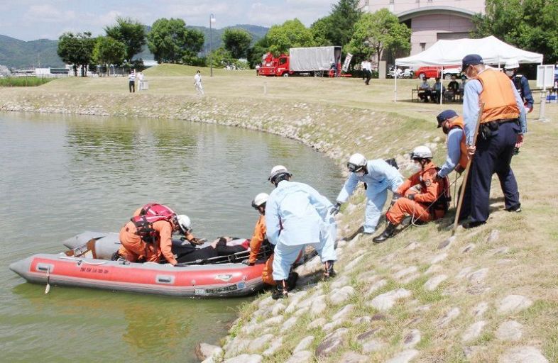 ボートで救助した男性を岸に引き上げる消防署員ら