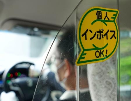 　インボイス制度の開始に備え、個人タクシーの車内に貼られたステッカー＝３０日午後、大阪市