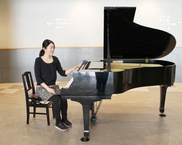 橋本さんと寄贈するピアノ。「音楽で地域を元気づけたい」と願う