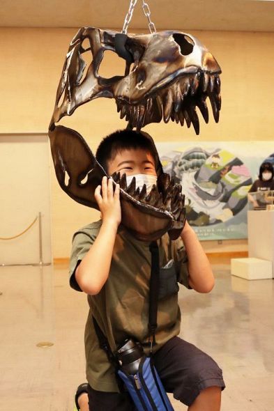 ティラノサウルスの頭骨をかぶって記念撮影。恐竜に食べられた気分？