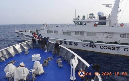 　４日、南シナ海のアユンギン礁付近で、フィリピン沿岸警備隊の巡視船（手前）を妨害する中国海警局の船（フィリピン沿岸警備隊提供、共同）
