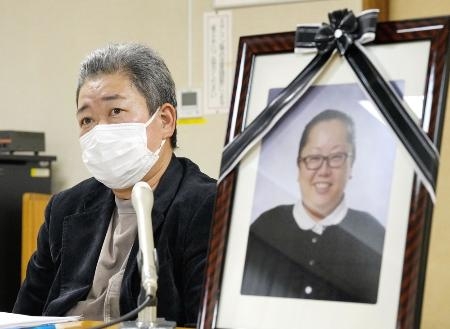 　２０２２年、飯岡綾乃さんの遺影を横に置き、記者会見する夫英治さん＝愛知県愛西市
