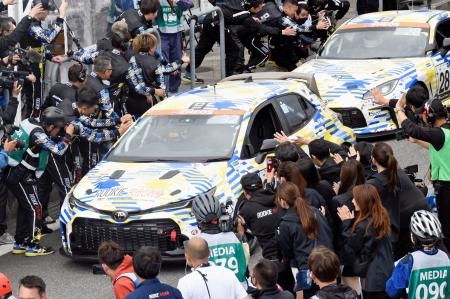 　２４時間耐久レースを完走し、関係者に出迎えられるトヨタ自動車の水素エンジン車＝２８日午後、静岡県小山町の富士スピードウェイ