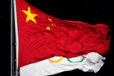 　２０２２年２月、冬季五輪開会式で五輪旗と重なった中国国旗＝北京（ＡＰ＝共同）