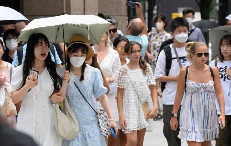 　東京・銀座で日傘を差して歩く人たち＝２２日午前