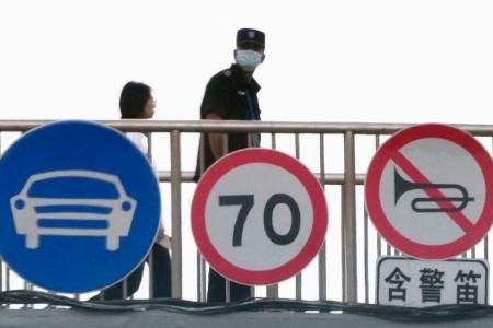 　高架橋の上で周囲を警戒する治安当局者（右）＝３日、北京（共同）