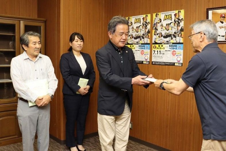 各団体の代表者にチケットを手渡す松尾理事長（右）