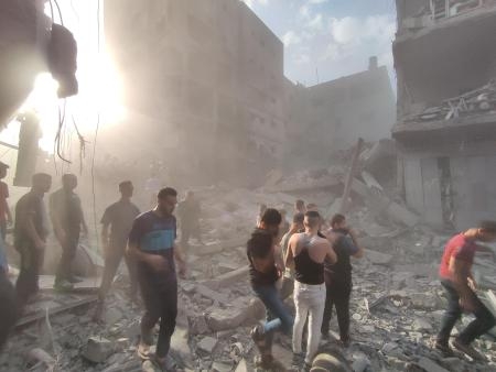 　イスラエル軍の攻撃で破壊された建物のがれきが散乱する中、不明者を捜索する人々＝２９日、パレスチナ自治区ガザ（ゲッティ＝共同）