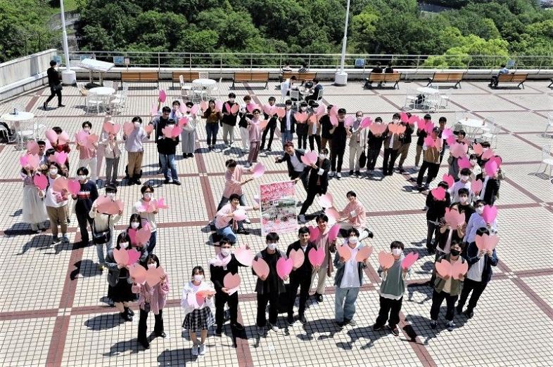 ピンクをまとって記念撮影する学生たち