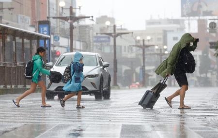 　台風６号の暴風雨に見舞われた鹿児島市内を歩く人たち＝９日午前