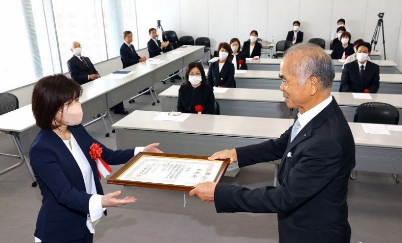 松田理事長から表彰状を受け取る受賞者（左）