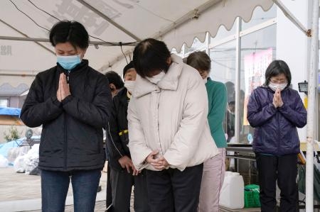 　石川県珠洲市の避難所で、能登半島地震の発生時刻に合わせ黙とうする避難者ら＝１日午後４時１０分