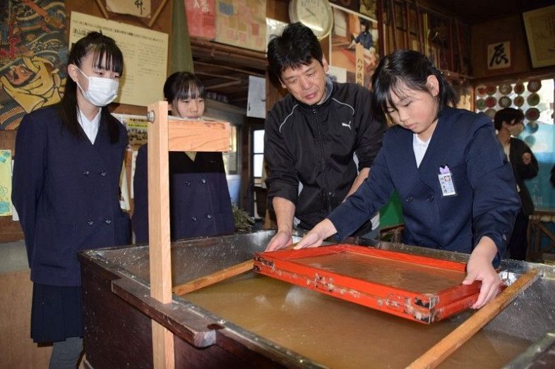 上田さん（右から２人目）に教わりながら卒業証書用の和紙をすく児童