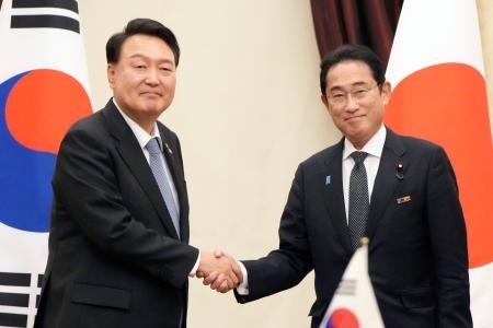 　会談前に韓国の尹錫悦大統領（左）と握手する岸田首相＝１２日、リトアニア・ビリニュス（共同）