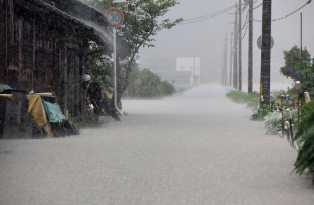 　大雨で冠水した道路＝１３日午後４時１５分ごろ、鳥取県岩美町