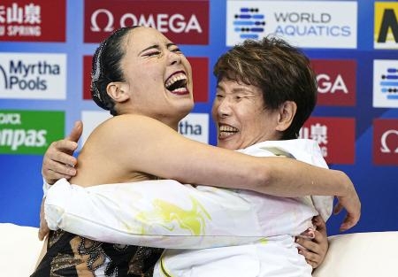 　世界水泳選手権のＡＳ女子ソロＦＲ決勝で、得点を確認して井村雅代コーチ（右）と抱き合って喜ぶ乾友紀子。２大会連続２冠を達成した＝１９日、マリンメッセ福岡