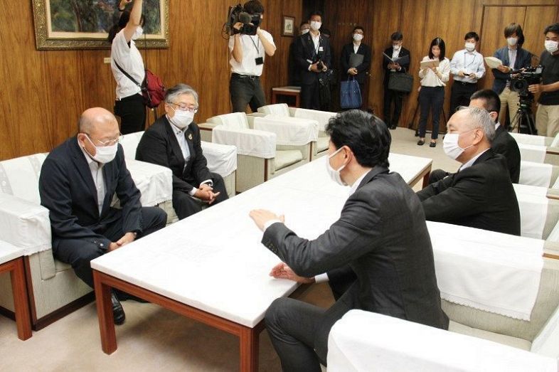 松田会長（左）に新卒者らの積極的な正規雇用を要請する伊原木知事（手前）